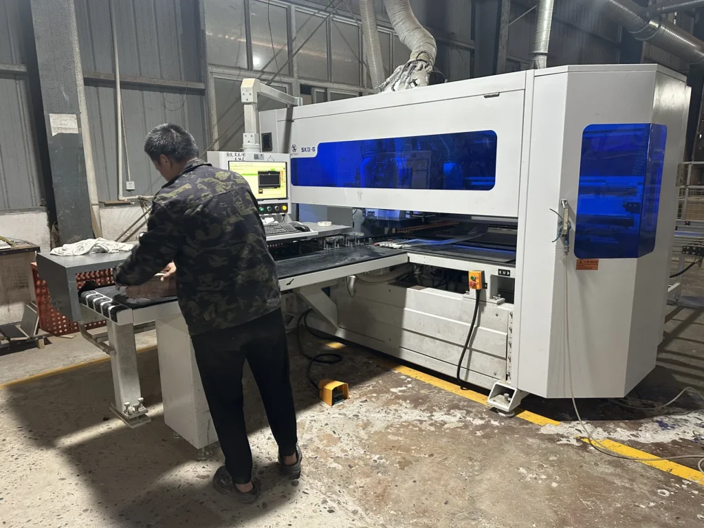 Operator working with enclosed CNC equipment during custom furniture production