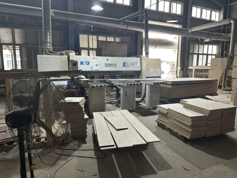 Cut wood panels staged beside panel processing equipment