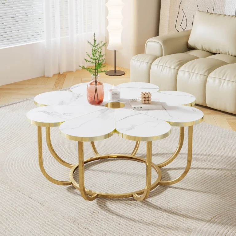 Flower-shaped white faux-marble coffee table with a gold-tone frame, with a vase and a small plant, beside a cream sofa