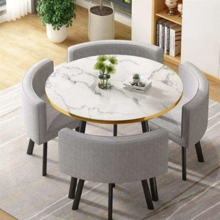 Round white marble-look table with gold edge band and four grey fabric chairs, top-down view