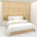 Light-oak bed with a white padded headboard, side shelves and a two-drawer nightstand against a light-oak wall panel