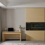Light-wood desk with a laptop beside a wood TV wall unit with a recessed screen and open niche