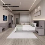 Room view along the beds with the bench, desk and wardrobe at the far wall