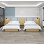 Twin layout with two beds, pale blue padded headboards and a small nightstand between them