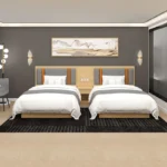 Twin layout with two made-up beds, gray headboards with orange stripes and a bedside table between them