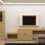 Mirror panel with coat hooks, TV in a wood frame with white side panels, desk with wood doors and a stool