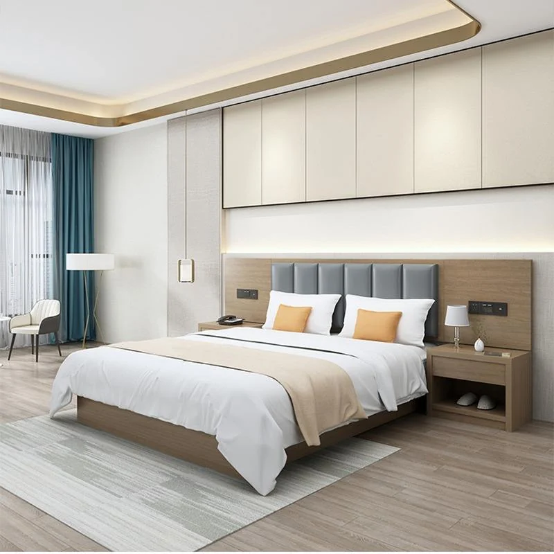 Made-up bed with a gray padded headboard on a wood backboard, orange cushions and open-shelf nightstands