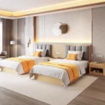 Twin beds with gray padded headboards and orange throws, with a floor lamp and an open-shelf nightstand with slippers
