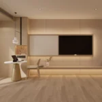 TV wall with a long light-wood shelf, a round table with a gold-tone pedestal and a wood chair