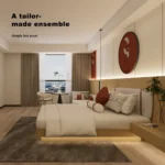 Bed seen from the side with the red wall disc, a window with a small table and the sofa behind