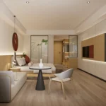 Seating corner with a cream sofa, a round table with black pedestal and an armchair, with the TV wall at the right