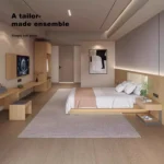 View toward the door with the light-wood bed, a desk and bench, a wall-mounted TV and a wardrobe