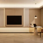 Wood TV wall with a long shelf below and a round table with a cream pedestal on a herringbone floor
