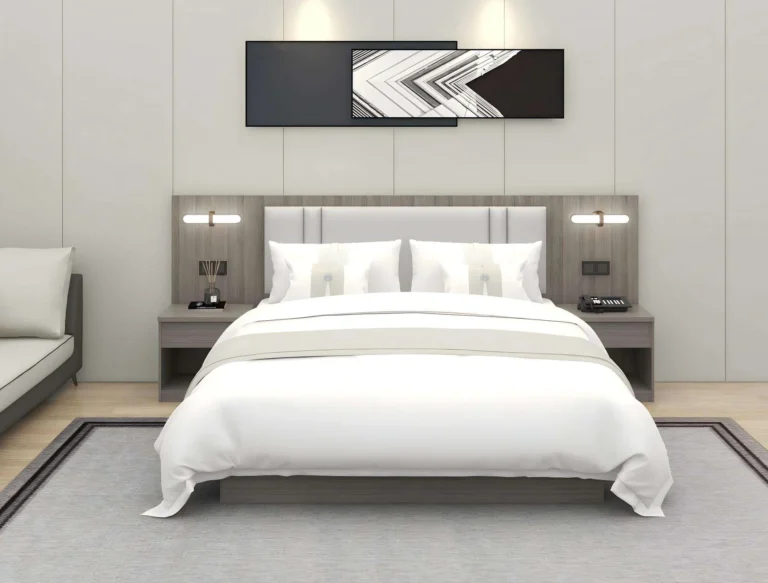 Wide bed with a light gray padded headboard on a gray wood-grain backboard with reading lights and floating nightstands