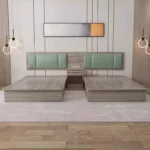 Twin gray wood-grain bed bases on a shared backboard with two mint-green headboards and a small nightstand between