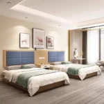 Twin beds with blue four-block padded headboards on a light-wood backboard, white-drawer nightstands and sage-green runners