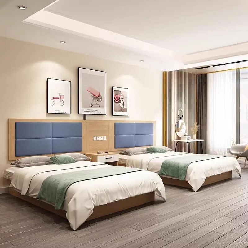 Twin beds with blue four-block padded headboards on a light-wood backboard, white-drawer nightstands and sage-green runners