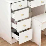 Four stacked drawers pulled open, with round knobs, beside the padded stool