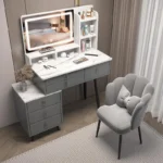 Gray vanity desk with a marble-look top, a lit LED mirror, a three-drawer cabinet and a scalloped gray chair