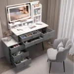 Gray vanity with the desk drawers and cabinet drawers pulled open, showing divided trays, beside a scalloped chair