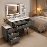 Gray vanity with a lit LED mirror and open drawers showing makeup, in a bedroom