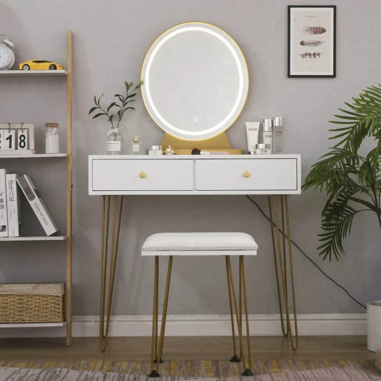 White slim vanity with a lit round LED mirror, two drawers, gold-tone hairpin legs and a padded stool, beside a ladder shelf