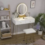 White slim vanity at a side angle, with a round LED mirror on a gold-tone base and a padded stool