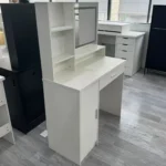 White vanity desk from the right side, showing the open shelf unit, the mirror and the drawer
