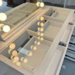 Close-up of the glass-covered desktop with divided compartments and the drawers on the right