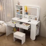 White vanity with two drawers and the cabinet door open, a rounded open-shelf end and a padded stool