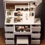 Close-up of the open drawers filled with makeup, the shelves behind the swung-open mirror door and the LED mirror border