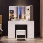 White vanity with a lit LED mirror, a side mirror door and seven drawers, against a dark wall