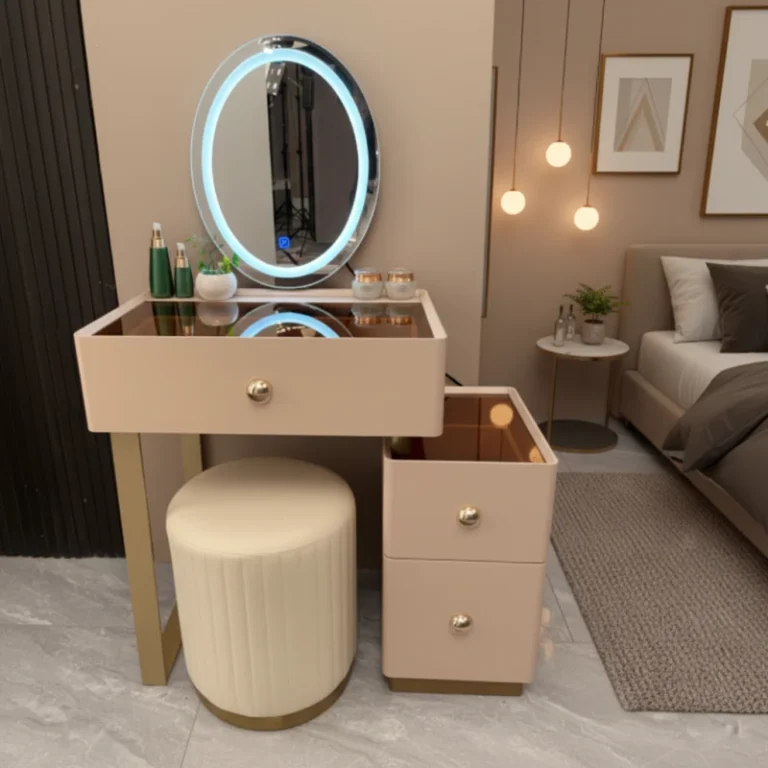 Blush-pink vanity with a glowing LED-ring mirror, a deep drawer, a two-drawer side unit and a cream round stool, in a bedroom