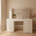 Cream-white wide vanity with a bulb-lit mirror, three front drawers and a drawer bank on each side, in a peach room