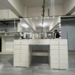 Front view of the white vanity with three drawers across the top and a drawer bank on each side, in a workshop