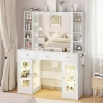 White vanity with a bulb-lit mirror, cubby shelves on both sides, three drawers and two lit glass-front cabinets