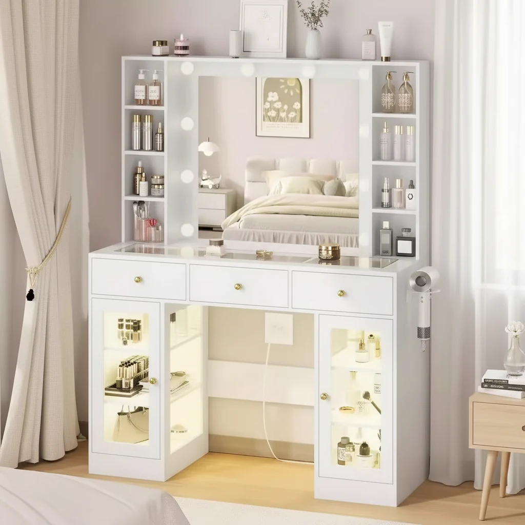 White vanity with a bulb-lit mirror, cubby shelves on both sides, three drawers and two lit glass-front cabinets
