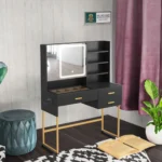 Black vanity desk with an LED mirror and a gold-tone base, with a pink curtain and an open book on the floor