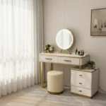 White fluted vanity with a round LED mirror, two wide drawers, a three-drawer cabinet and a cream round stool, by curtains