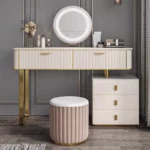 Cream-white fluted vanity with a round LED mirror, two wide drawers, a three-drawer cabinet and a pink fluted stool